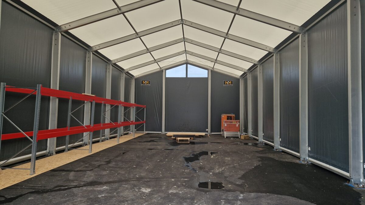 Wnętrze hali przemysłowej od Hallgruppen, z pustymi półkami i otwartą przestrzenią gotową do magazynowania.