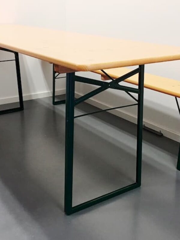 Pomarańczowy zestaw stołu i ławek od Hallgruppen, ustawiony wewnątrz na szarej podłodze. Meble są solidne i dostarczone przez Hallgruppen.
